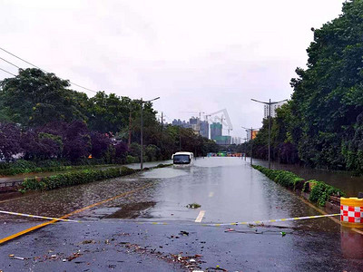 暴雨后被水淹没的道路公交车行驶在水中摄影图配图