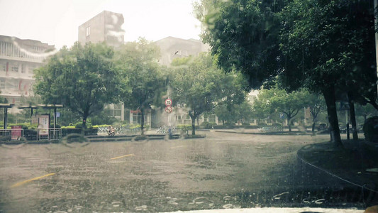 暴雨摄影照片_大雨下雨天雨滴打落在汽车挡风玻璃上雨刷运行