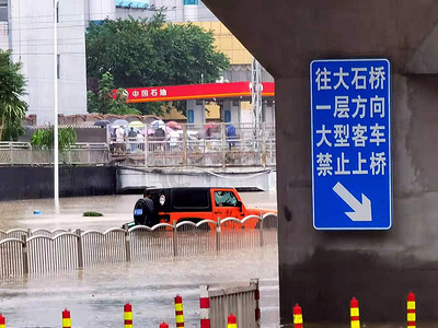 暴雨摄影照片_暴雨中行驶的车辆摄影图配图