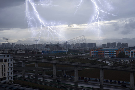 雷雨交加摄影照片_天气气候白天闪电打雷城市建筑风景实拍摄影图配图