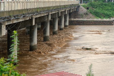 台风图摄影照片_暴雨夏季河流桥梁下洪涝摄影图配图