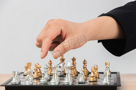 人物棋牌摄影照片_下棋白天国际象棋室内手摄影图配图