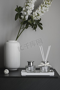 空气图摄影照片_桌面花瓶装饰与玻璃瓶熏香摄影图配图