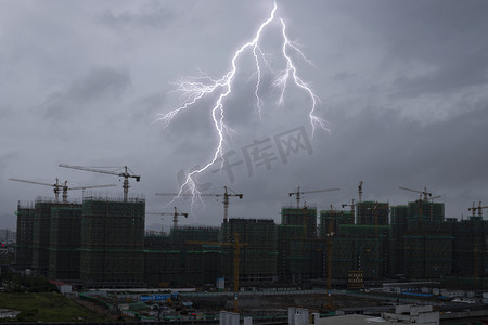 雷阵雨转中雨摄影照片_雷电天气白天雷电交加城市建筑风景实拍摄影图配图