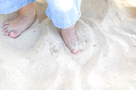 旅游傍晚宝宝沙滩上踩沙子摄影图配图