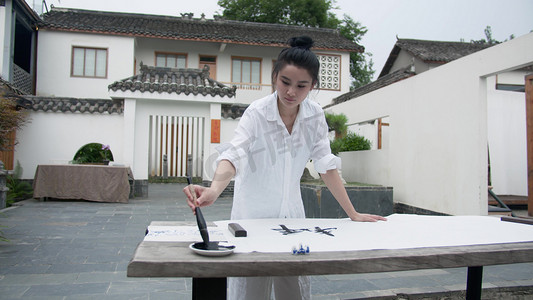 练字摄影照片_实拍美女中国风庭院写毛笔字