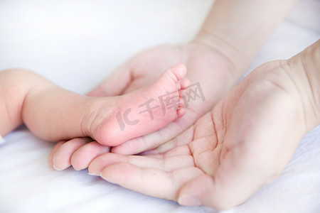 母婴摄影照片_婴儿脚丫婴儿新生大手小脚三胎摄影图配图