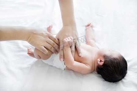 婴儿新生摄影照片_婴儿护理新生母婴穿尿不湿照顾宝宝摄影图配图