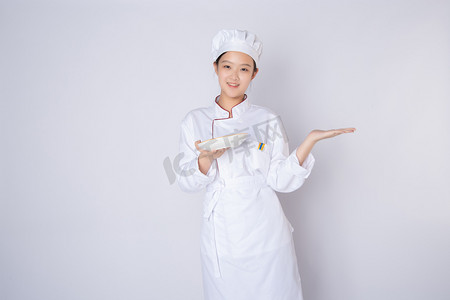 年轻女厨师白天白背景白背景有请进入动作摄影图配图