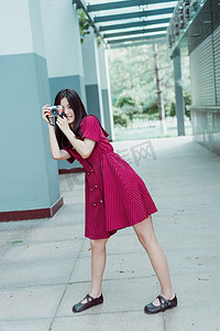 夏日文艺人像白天红裙女生校园内拿相机拍照摄影图配图