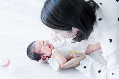 国潮婴儿照摄影照片_婴儿护理三胎母婴人像照顾宝宝摄影图配图