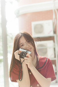 夏日文艺人像白天长发美女阳光下开心的拿着相机摄影图配图