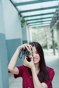 相机拍照图摄影照片_夏日文艺人像白天长发美女校园中拿着相机拍照摄影图配图