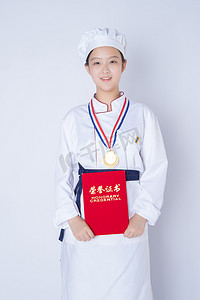 年轻女厨师白天一个女厨师白背景双手抱着获奖证书摄影图配图