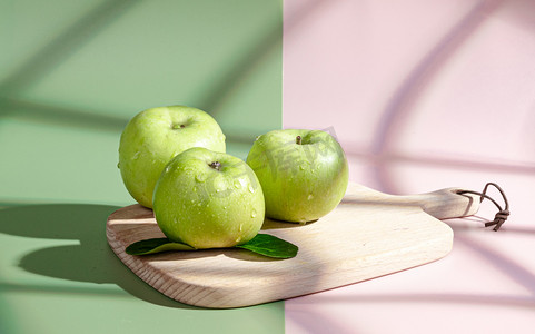 绿色水果白昼三个青苹果室内砧板阳光照射摄影图配图