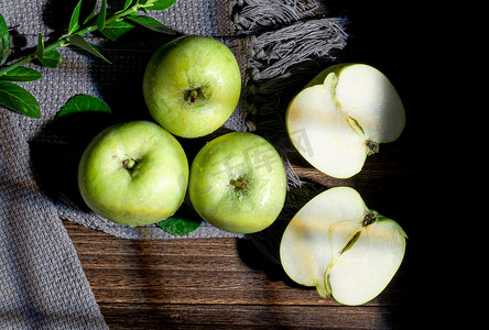 水果摄影照片_绿色水果白昼新鲜青苹果室内阳光照射摄影图配图