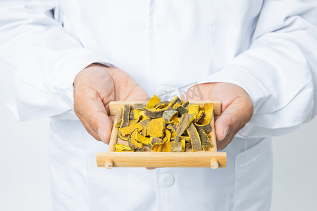 中医白天穿着白大褂的老中医室内双手捧着中药材摄影图配图