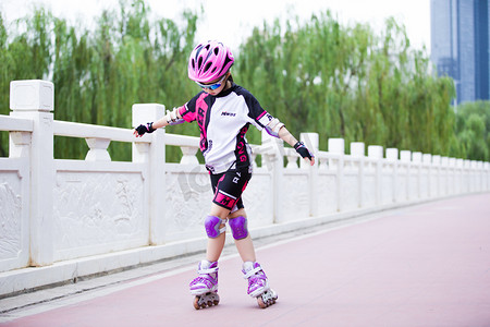 轮滑小孩摄影照片_轮滑玩轮滑的小女孩人像健身体育摄影图配图