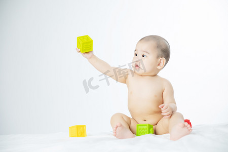 月嫂摄影照片_母婴白天男婴室内拿起玩具摄影图配图