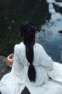 坐在溪水旁边的古风美女背影摄影图配图