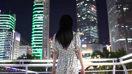 美女张开双臂拥抱希望未来背影城市高楼大厦夜景