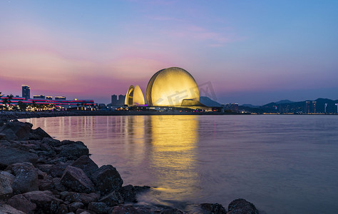 海滩晚霞摄影照片_珠海日月贝灯光夜晚建筑路面拍摄摄影图配图