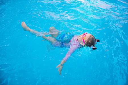 泳装摄影照片_暑期培训白天女童游泳馆仰泳摄影图配图