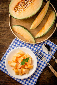 美食白天哈密瓜和果肉室内餐布上摄影图配图