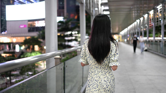夏季傍晚美女下班在天桥行走背影