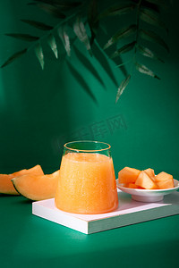 饮品绿色摄影照片_美食白天一杯哈密瓜汁室内托盘上摄影图配图