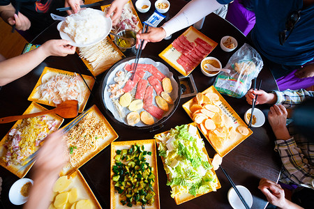 朝鲜族聚餐摄影照片_餐饮美食夜晚烤肉餐馆吃晚餐摄影图配图