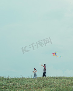 放风筝摄影照片_父女中午放风筝草海放风筝摄影图配图