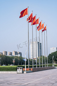 飘扬红旗摄影照片_市政府前迎风飘扬的红旗风景摄影图配图