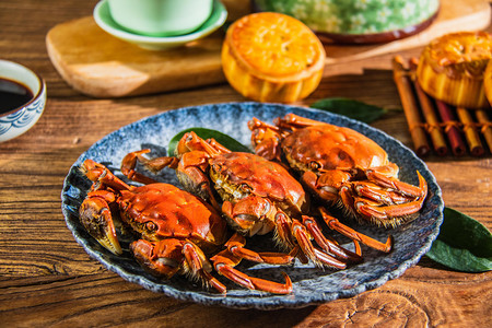 欢度中秋佳节摄影照片_中秋节美食白天螃蟹和月饼餐桌吃午餐摄影图配图