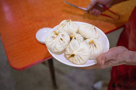 早餐铺摄影照片_早餐包子图片上午一个人室内服务摄影图配图