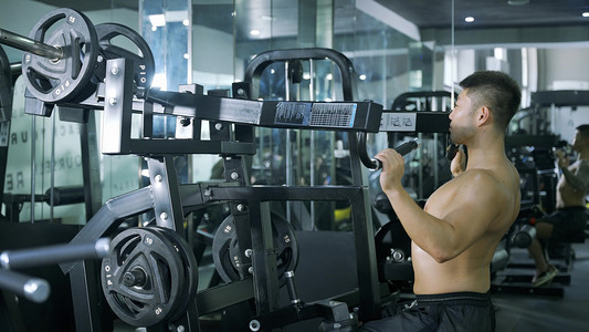 线条流汗摄影照片_男性锻炼大型器材背部训练健身教练健身运动