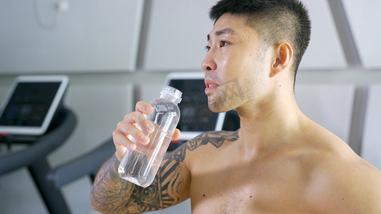 喝矿泉水摄影照片_健硕男运动员补充水分喝水营养健身运动