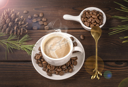 咖啡杯摄影照片_木板上松树枝咖啡豆与一杯美味咖啡摄影图配图