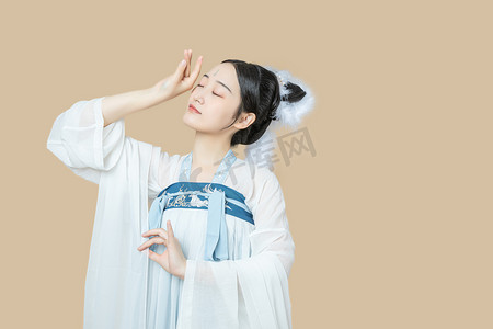 嫦娥摄影照片_汉服文化白天汉服美女室内用手抚摸额头摄影图配图