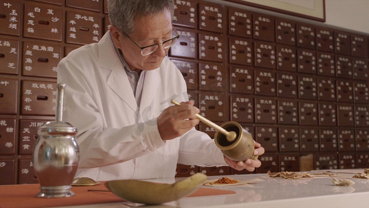 药摄影照片_老中医抓药捣药研磨过程