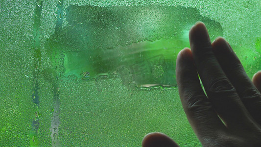 手抹玻璃窗上的雨水水滴擦水
