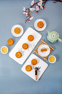 咸蛋黄摄影照片_美食白日糕点月饼室内梅花旁摄影图配图