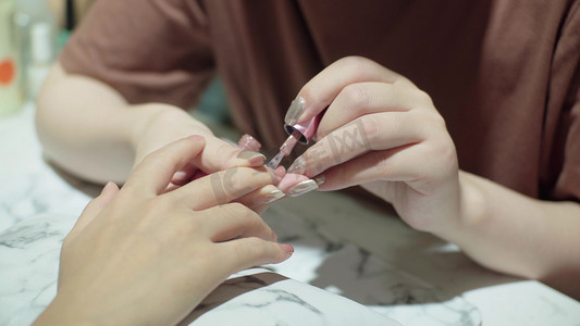 实拍美甲技师给客户涂指甲油广告