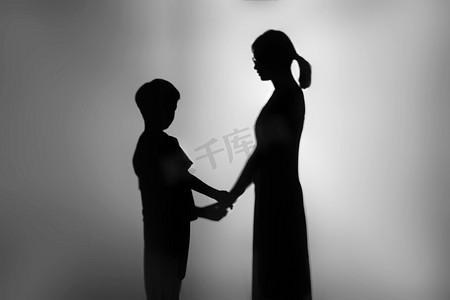 拧儿子耳朵摄影图配图人像剪影夜晚夫妻两人在室内面对面伸出双手摄影