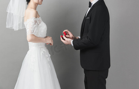 求婚人物摄影照片_婚礼人物白天新郎新娘礼堂送钻戒摄影图配图