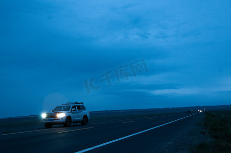 新疆美景傍晚公路上行驶的汽车摄影图配图