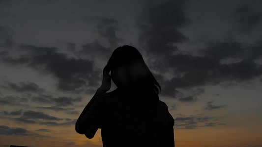傍晚夕阳下美女失落剪影