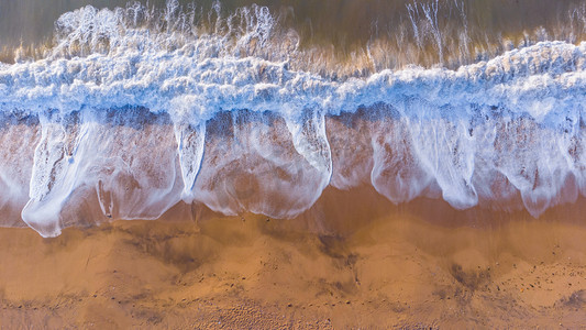 蓝色夏季沙滩摄影照片_浪花白天海浪沙滩海边海浪摄影图配图
