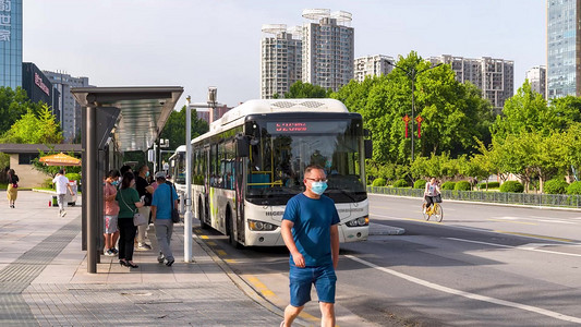 公交车站台人流摄影照片_城市公交车站台上班早高峰人流