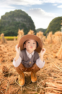 噘嘴可爱的男孩在水稻田里摄影图配图